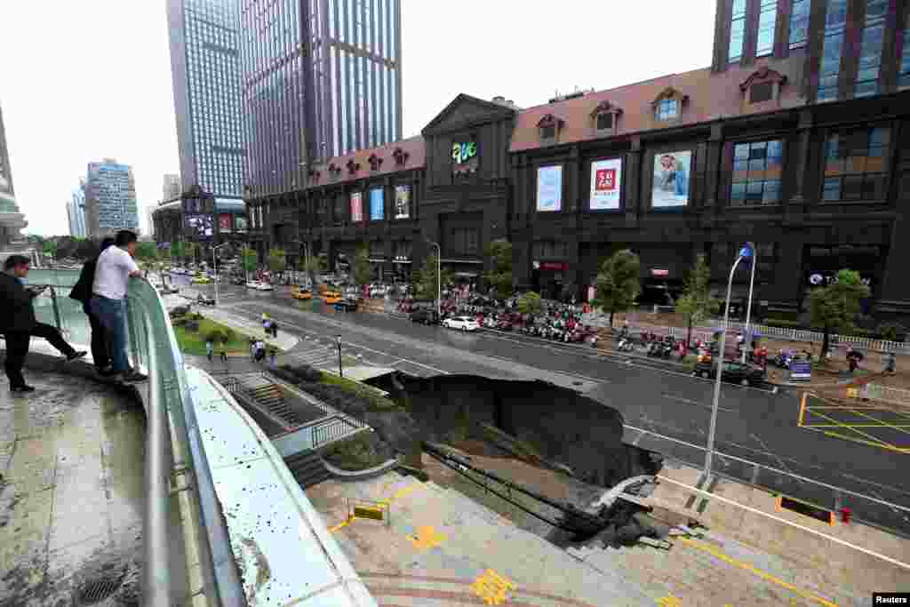 2017年6月10日，在中国江苏省南通市，人们看看塌陷的道路。路面因工地渗水而坍塌，有汽车掉下去。27日，南通市政府通报，道路塌陷事故原因查明，主要为地下径流所致，此外，地表下脱空的形成与基坑回填土不密实有一定关系。