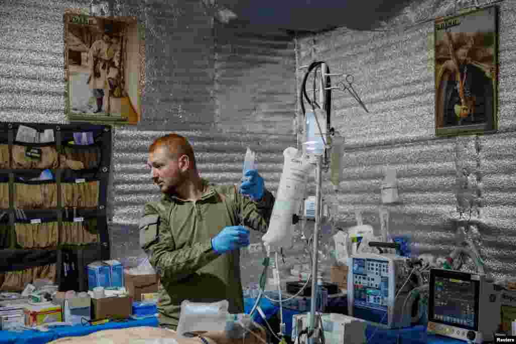 Un médico prepara un suero mientras asiste a un militar ucraniano herido en un hospital de campaña cerca de la ciudad de Chasiv Yar, en la región de Donetsk, Ucrania, el 1 de julio de 2024.