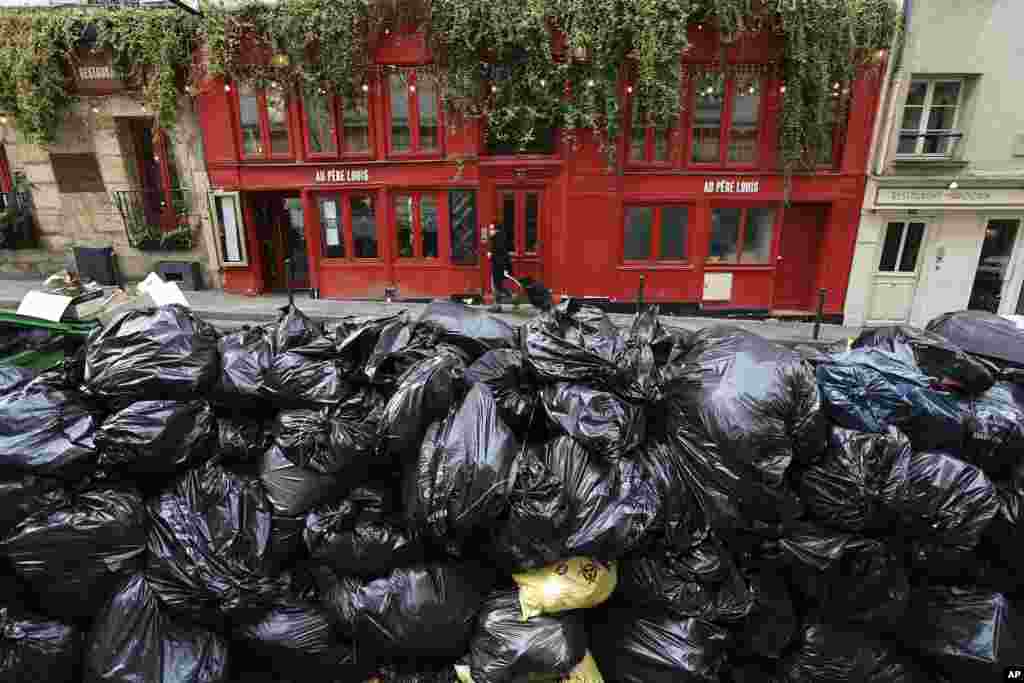 Uncollected garbage is piled up on a street in Paris.&nbsp;France&#39;s government is fighting for its survival against no-confidence motions filed by lawmakers who are furious that President Emmanuel Macron used special constitutional powers to force through an unpopular bill raising the retirement age from 62 to 64 without giving them a vote.