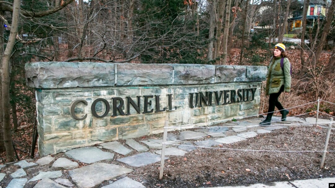 Una mujer camina junto a un anuncio de la Universidad de Cornell en el campus de esta escuela de la Ivy League en Ithaca, Nueva York, el 14 de enero de 2022. 