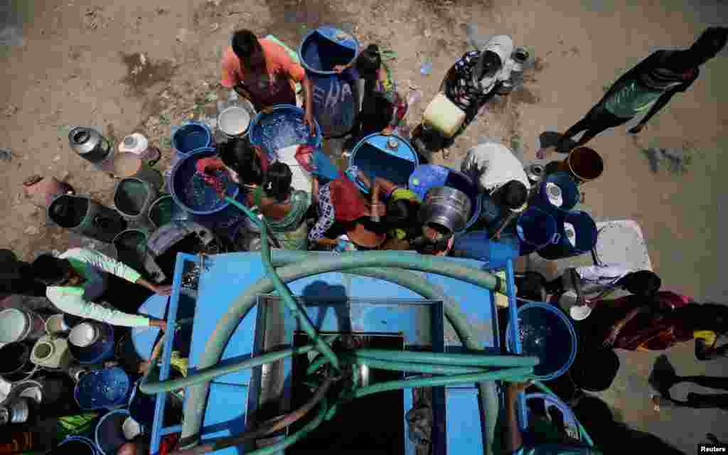 Local residents fill their empty containers with water from a municipal corporation tanker on a hot summer day in Ahmedabad, India, May 20, 2019.