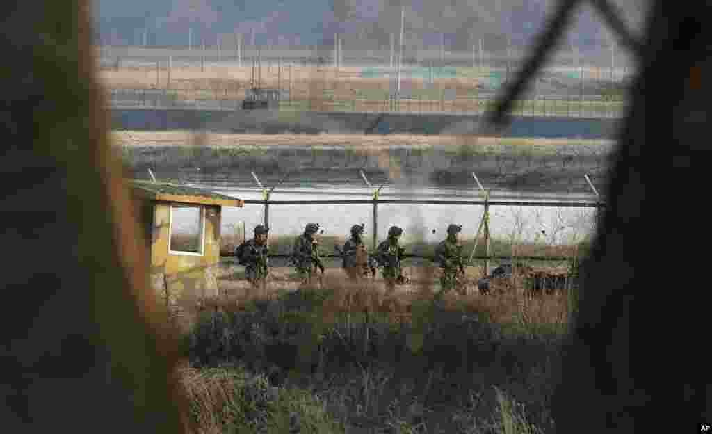 2013年3月27日，韩国士兵在韩国坡州板门店边界村附近沿着铁丝网巡逻。