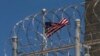 Флаг США развевается внутри ограждения из колючей проволоки на территории следственного изолятора на военно-морской базе США Гуантанамо, на Кубе. 17 апреля 2019 года.