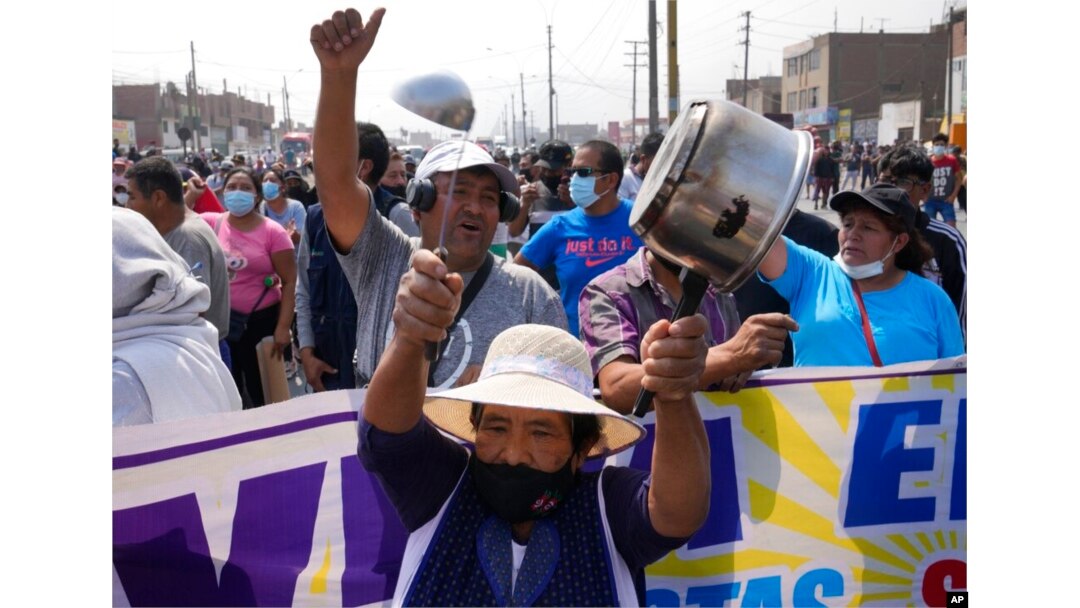 Conductores y residentes protestan en la Autopista Central, donde autobuses y camiones quedaron estacionados para cortar la carrtera, en Huaycan, en las afueras de Lima, Perú, el lunes 4 de abril de 2022.