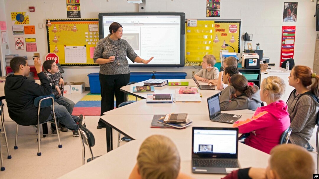 FILE - In this photo taken Feb. 12, 2015, sixth grade teacher Carrie Young guides her students through an exercise on their laptops. (AP Photo/Ty Wright) 