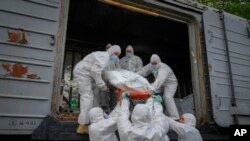 Ushtarakët ukrainas transportojnë kufomat e ushtarëve rusë në një vagon treni frigoriferik (Kiev, 13 maj 2022)