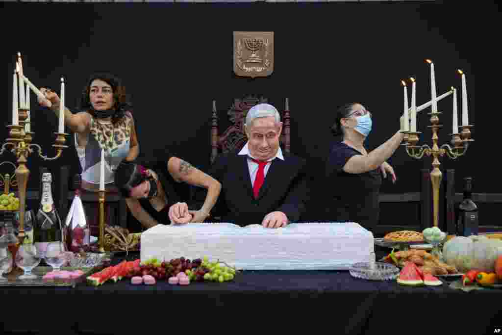 Team members of Israeli artist Itay Zalait work on an installation depicting Prime Minister Benjamin Netanyahu at a mock &quot;Last Supper&quot; at Rabin square in Tel Aviv.