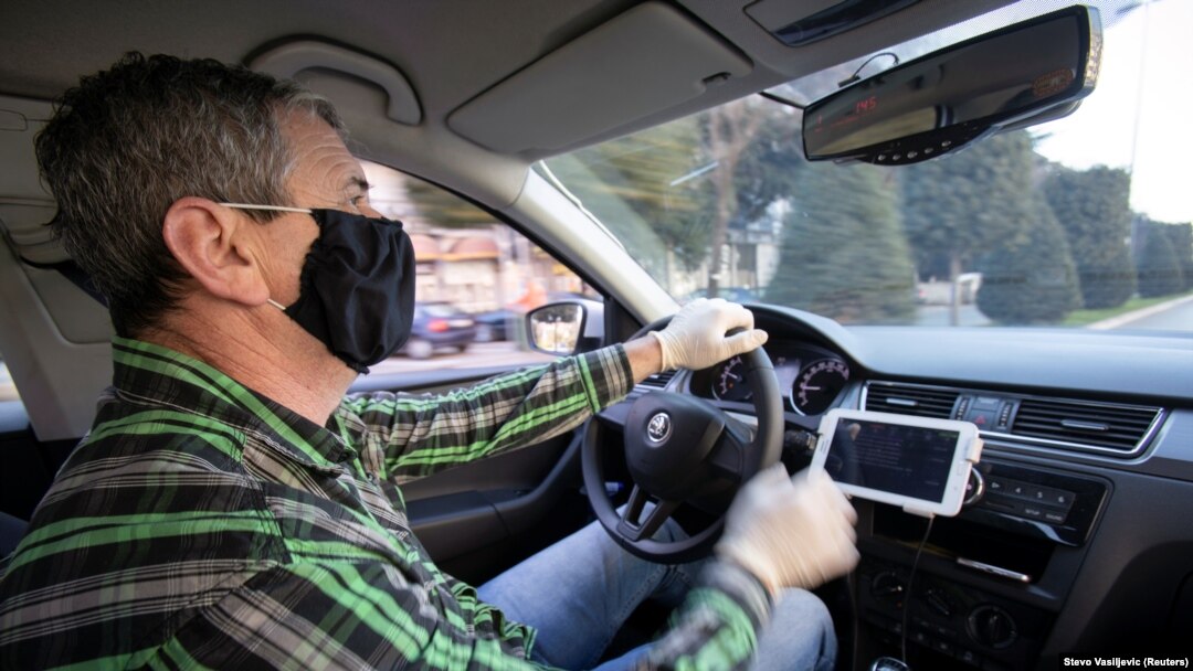 Montenegro, Podgorica, A taxi driver wears a protective mask and gloves after government ban all public transport due first two registred cases of coronavirus