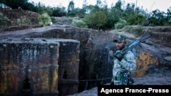 Umurwanyi wa TPLF ahagaze ahari isengero ry'umweranda Saint George i Lalibela, muri Etiyopiya, Kw'itariki 07/12/2021