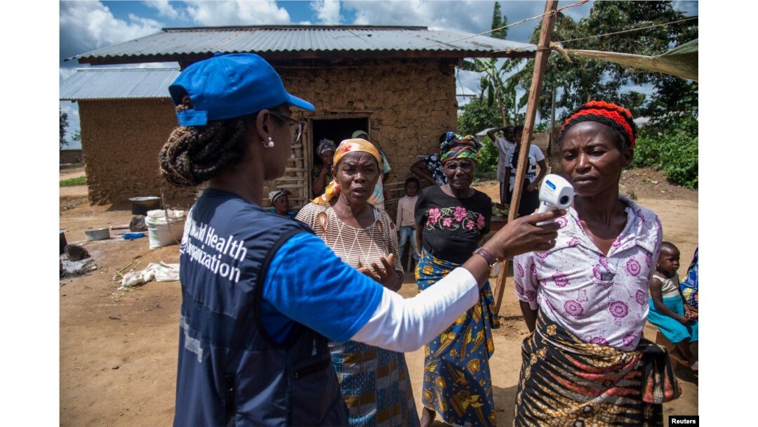 La doctora Marie-Roseline Darnycka Bélizaire, de la Organización Mundial de la Salu, habla con mujeres como parte de la estrategia para detectar posibles contactos de personas infectadas con ébola en Mangina, en la República Democrática del Congo, el 26 de agosto de 2018.