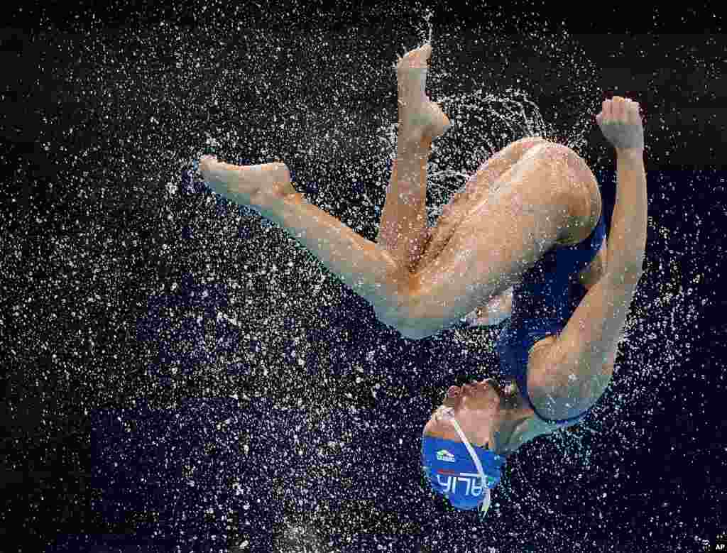 A member of the Italy team is thrown up in the air during a synchronized swimming training session ahead of the FINA Swimming World Championships in Barcelona, Spain, July 18, 2013.