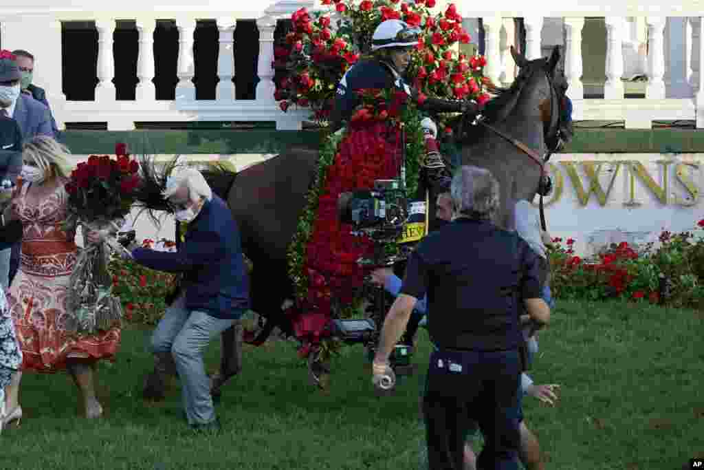 Trainer Bob Baffert is knocked to ground as Jockey John Velazquez try to control Authentic in the winners' circle after winning the 146th running of the Kentucky Derby at Churchill Downs, Sept. 5, 2020, in Louisville, Kentucky.