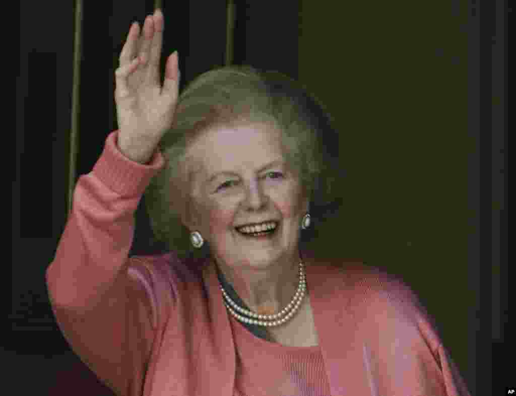 英国前首相撒切尔夫人2009年6月29日在从医院返回家中后,站在家门口向记者们招手。
