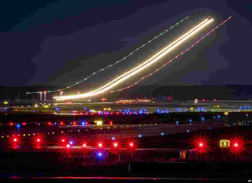 This long time exposure photo shows the lights of an aircraft while landing at the airport in Frankfurt, Germany.