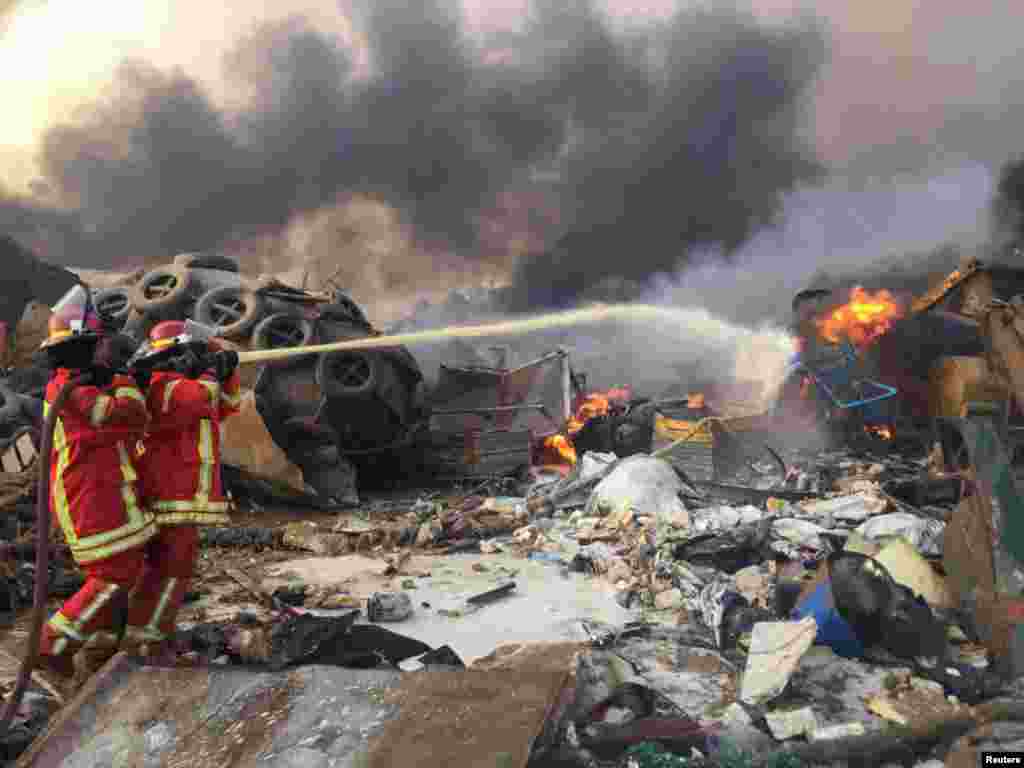 Firefighters extinguish a fire after an explosion was heard in Beirut, Lebanon.
