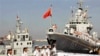 中国海军官兵登上青岛号导弹驱逐舰（右）去参加2013年9月中美海军联合演习。
