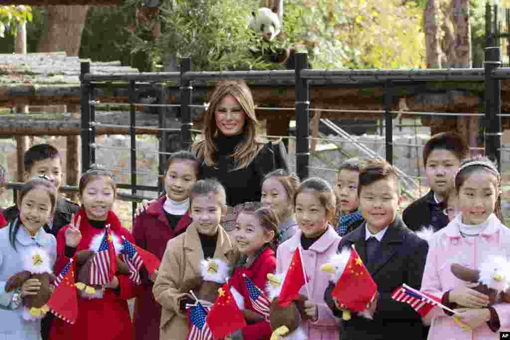 美国第一夫人梅拉尼娅·川普参观北京动物园,,在熊猫馆附近,把美国秃鹰玩具送给欢迎她的儿童(2017年11月10日)。