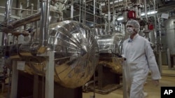 ARCHIVO - Un agente de seguridad iraní con ropa protectora recorre parte de la Planta de Conversión de Uranio, a las afueras de la ciudad iraní de Isfahán. 