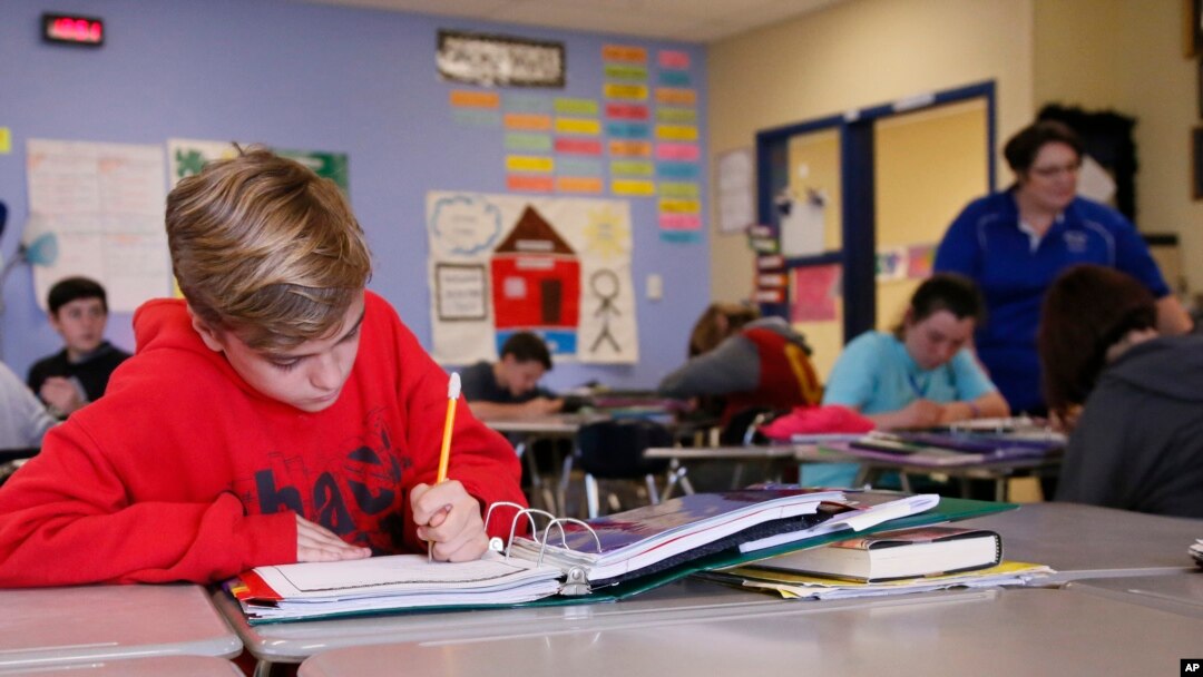 FILE - Seventh-grade students
attend English class in Newcastle, Oklahoma on March 30, 2017. The latest test scores show that American 13-year-old students are back to their lowest level in math since 1990 and lowest reading level since 2004. (AP Photo/Sue Ogrocki)