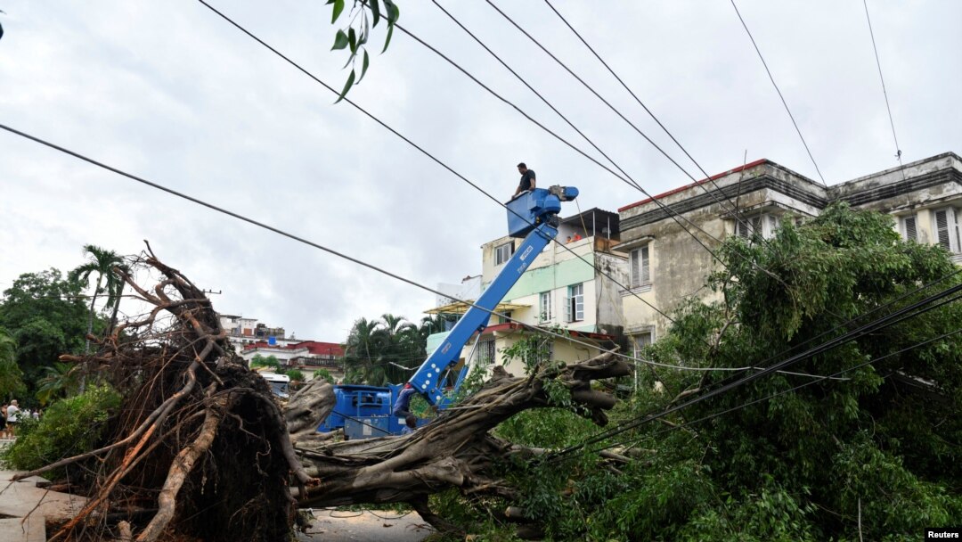 Trabajadores retiran árboles caídos sobre cables eléctricos un día después de que el huracán Rafael dejara sin servicio de electricidad al país, provocando un apagón que afectó a 10 millones de personas. La Habana, Cuba, 7 de noviembre de 2024. REUTERS/Norlys Pérez.