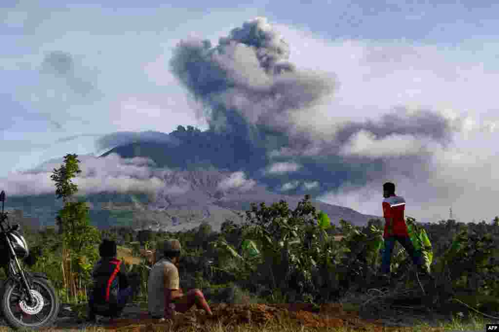 Villagers watch the eruption of Mount Sinabung as seen from Karo, North Sumatra, Indonesia.