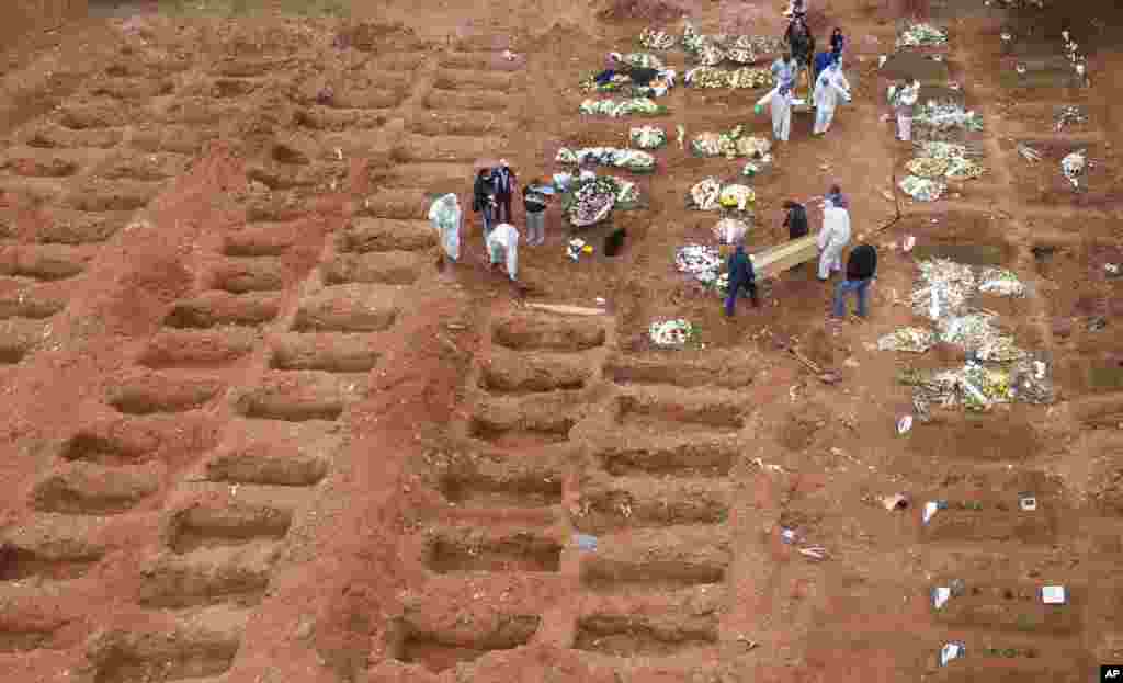 Cemetery workers in protective clothing bury three victims of the new coronavirus at the Vila Formosa cemetery in Sao Paulo, Brazil.&nbsp;Brazil is nearing two million cases of COVID-19 and 75,000 deaths.&nbsp;