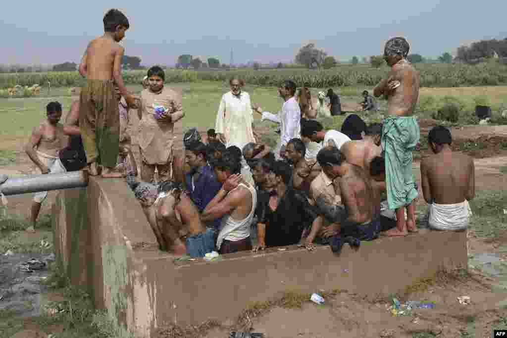 Farmers and vendors take bath at a cattle market set to buy sacrificial animals ahead of Eid al-Adha Muslim festival or the &#39;Festival of sacrifice&#39; in Lahore, Pakistan.
