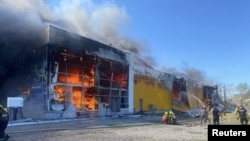 Equipos de rescate intentan contener un incendio en un centro comercial en Kremenchuk, en el este de Ucrania, tras el impacto de misiles rusos, el 27 de junio de 2022.