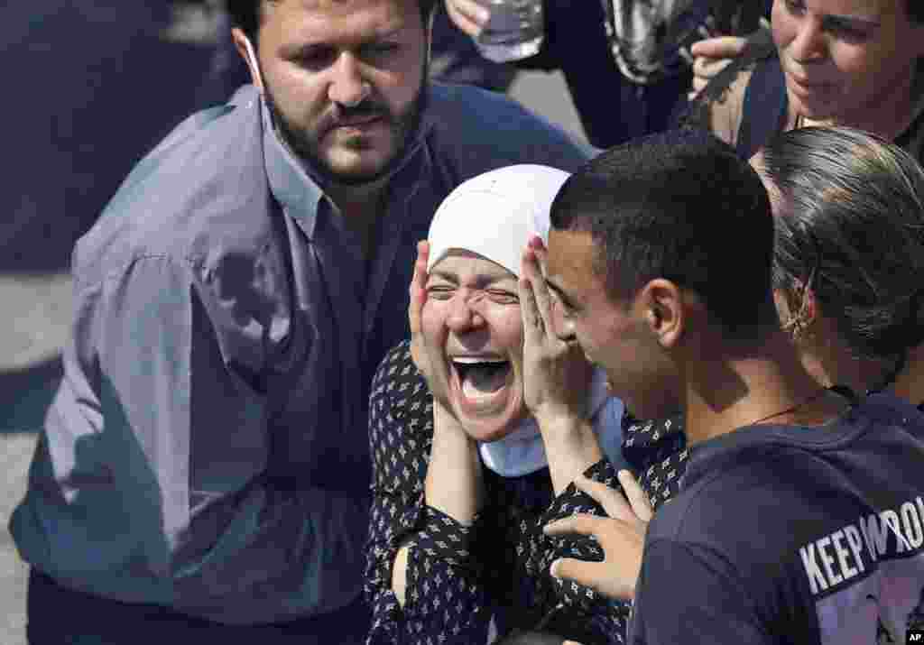 The wife of Rami Kaaki, one of ten firefighters who were killed during the last week's explosion that hit the seaport of Beirut, Lebanon, mourns during her husband's funeral at the firefighter headquarters.