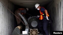 Los inspectores panameños trabajan en uno de los contenedores donde fueron encontradas las armas cubanas sin declarar.